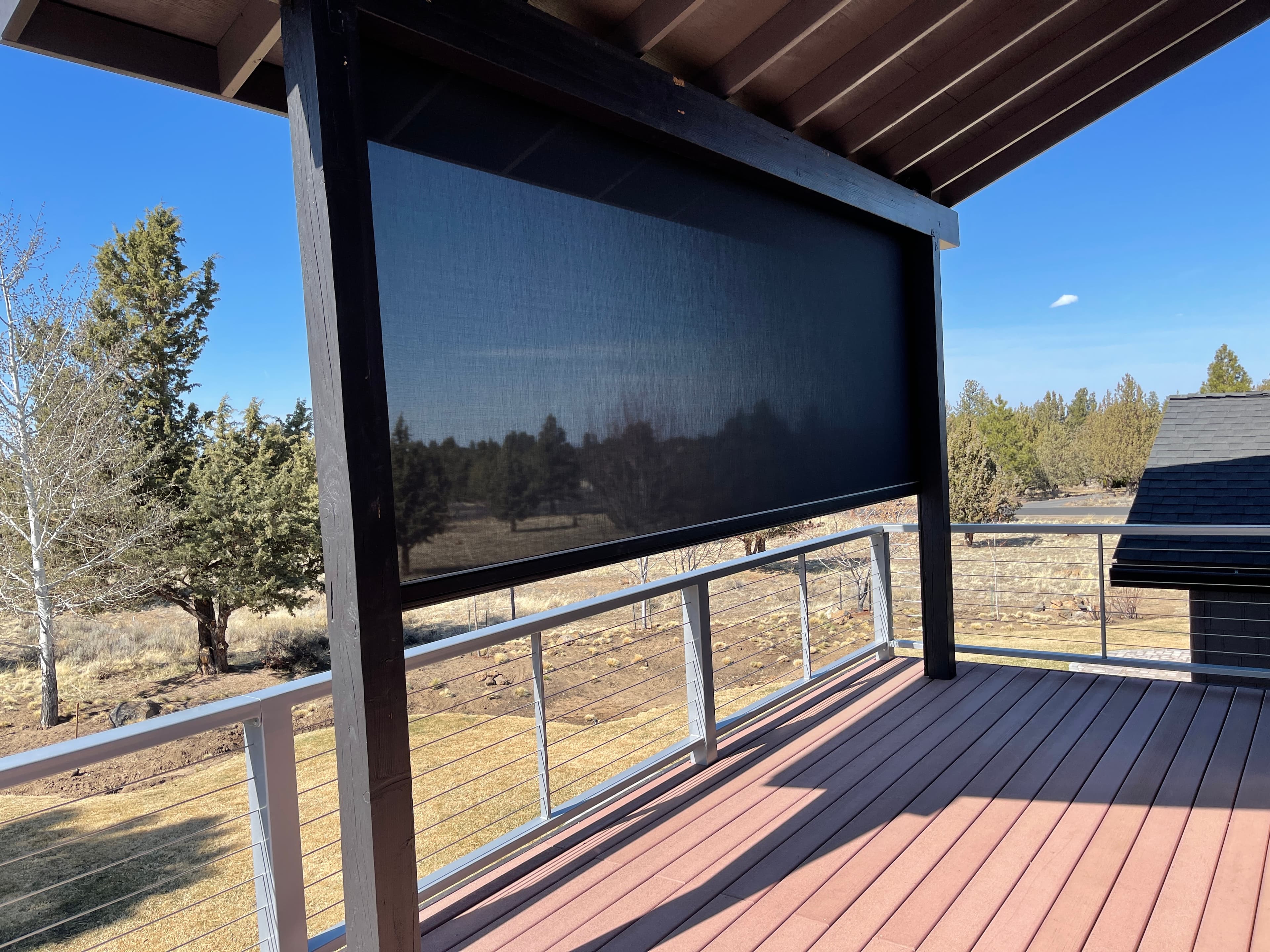 Motorized exterior solar shade install on a covered deck by Luxe Window Works in North Idaho