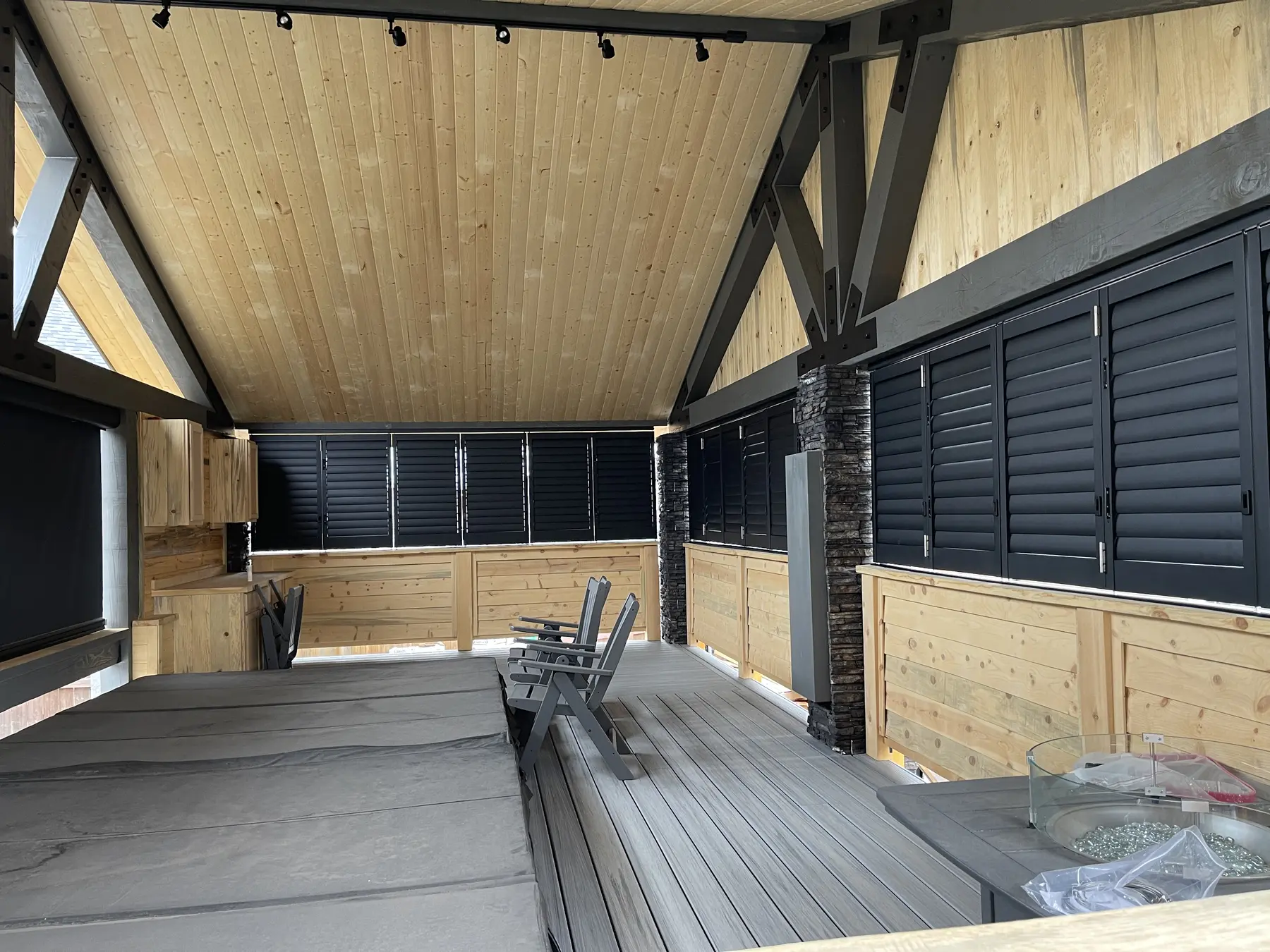 Dark outdoor shades enclosing a timber patio structure