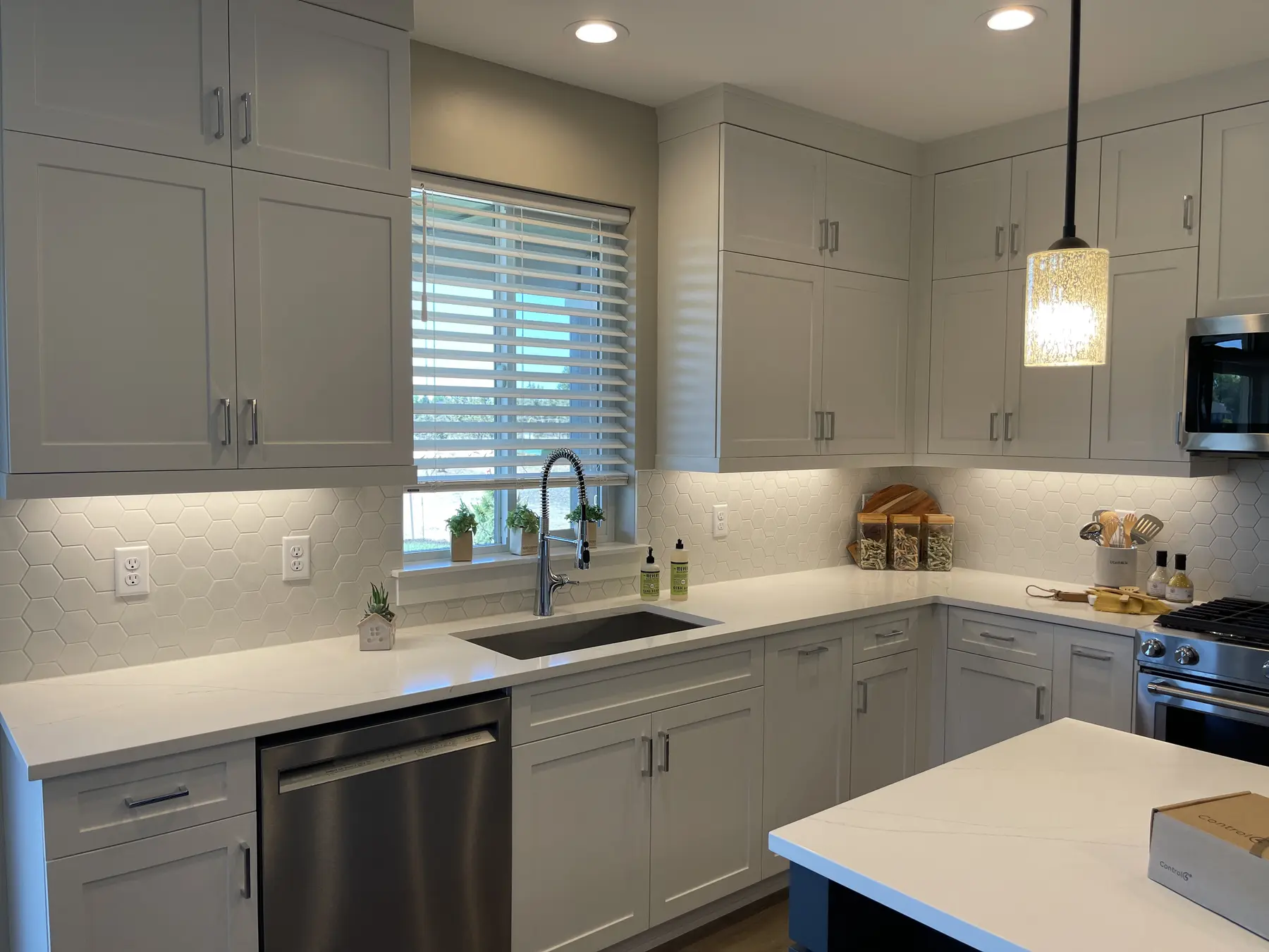 White horizontal blind installed above a kitchen sink