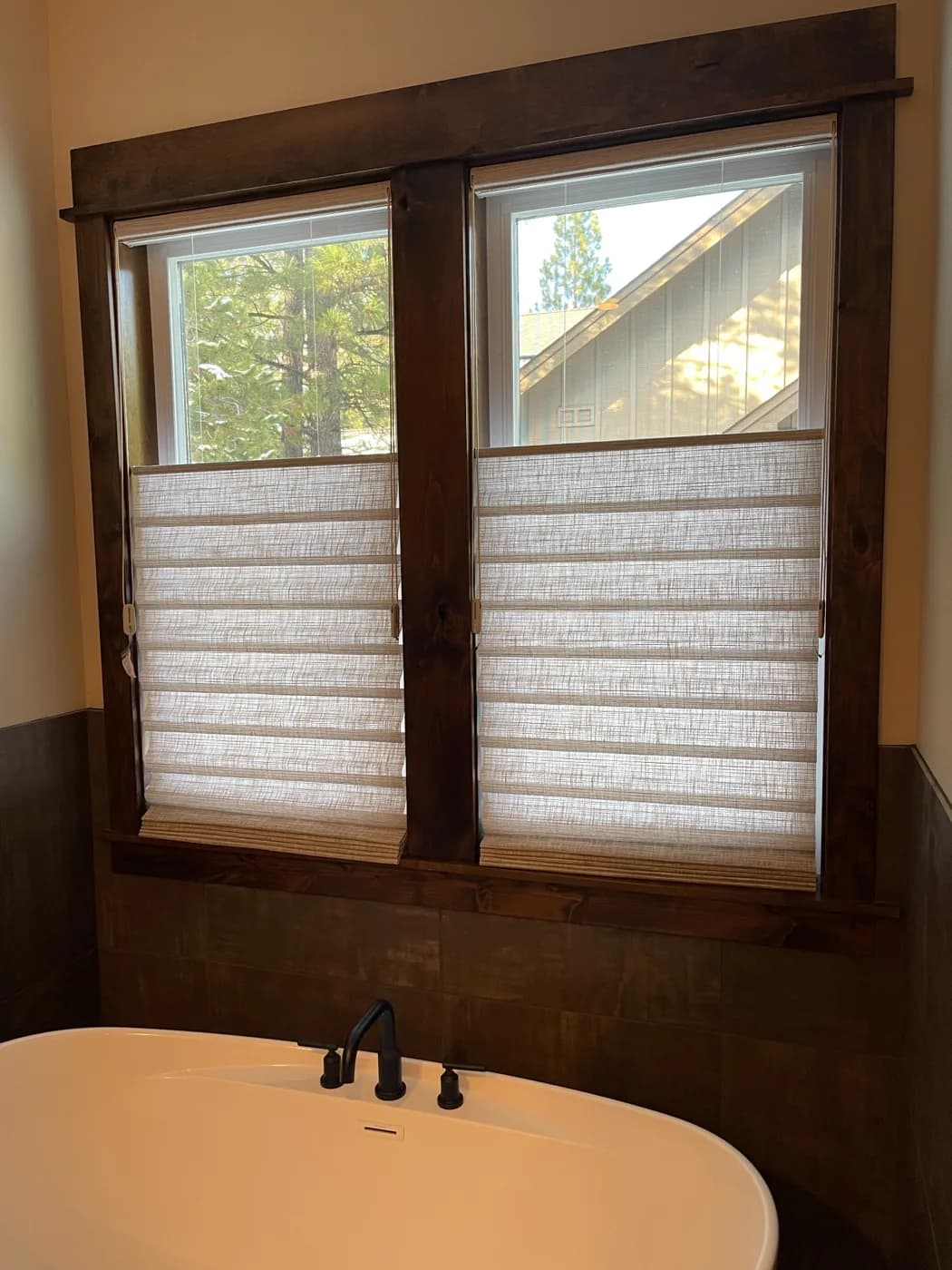 Hunter Douglas fabric shades above a freestanding bathtub