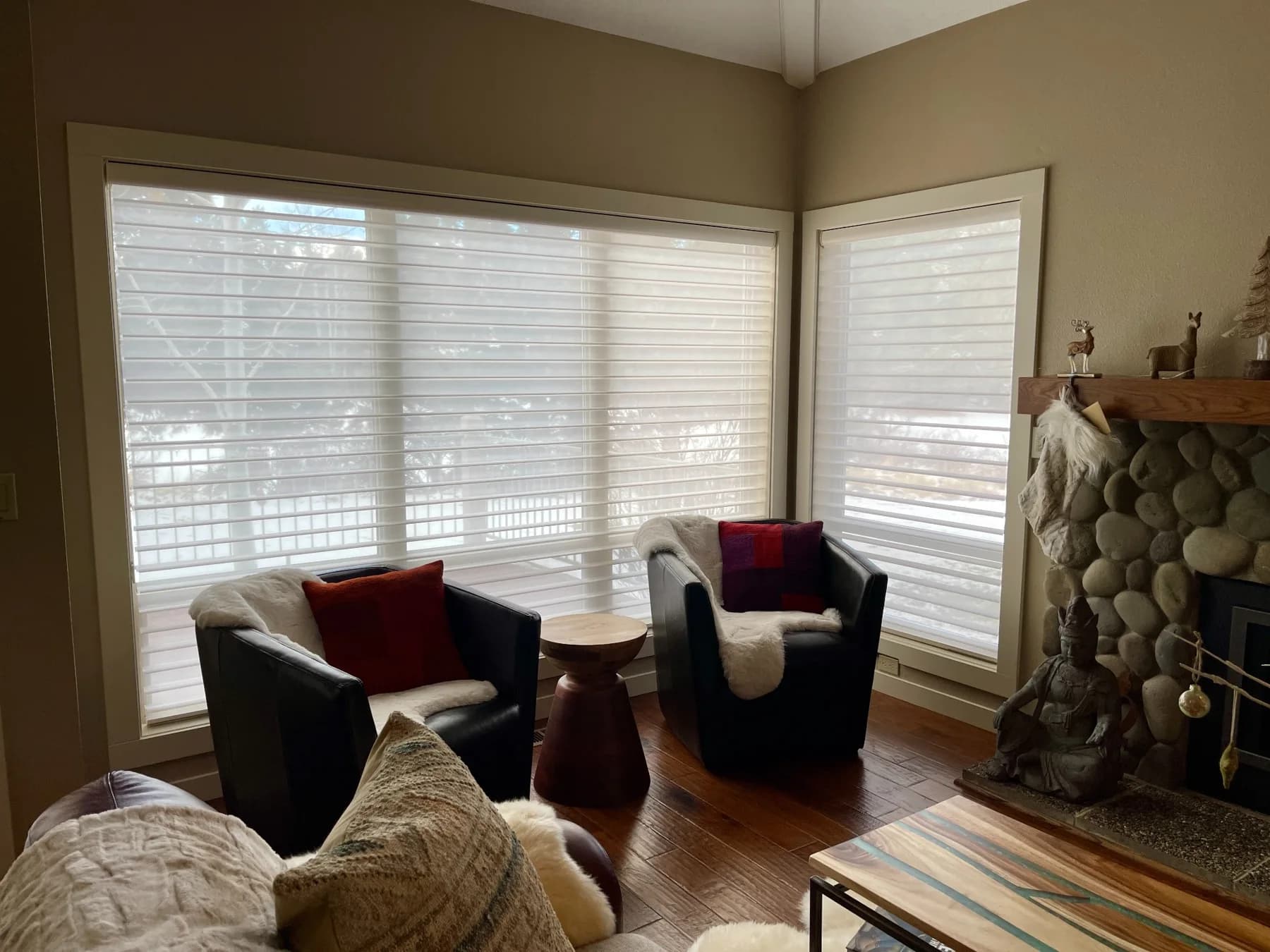 Hunter Douglas sheer shades filtering daylight beside a sitting area and stone fireplace