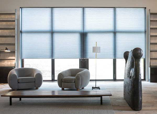 Large honeycomb cellular shades in a minimalist modern living room providing energy-efficient insulation for Northern Idaho homes