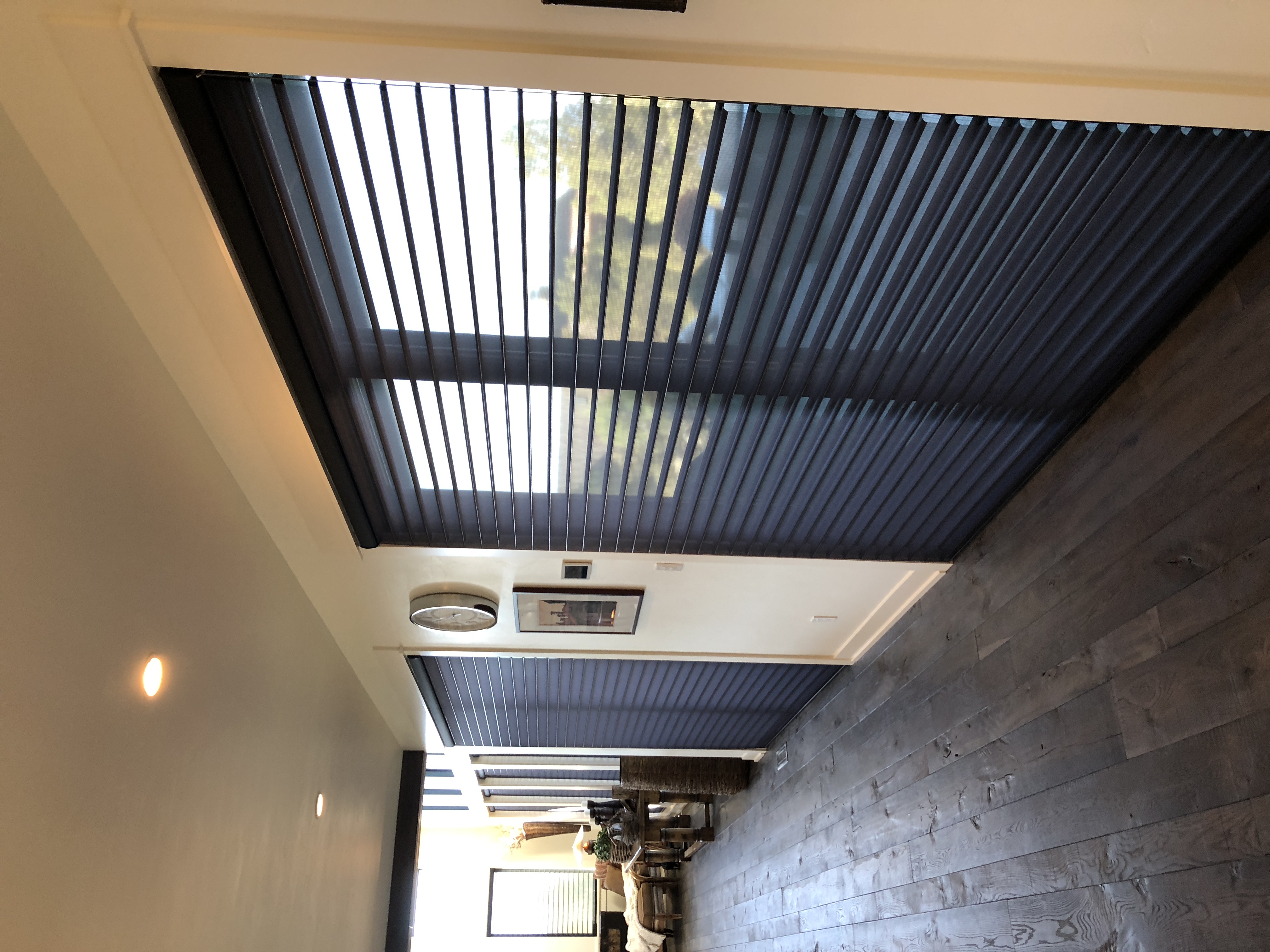 Layered shutters and motorized shades installed in a northern Idaho home for light control and energy efficiency